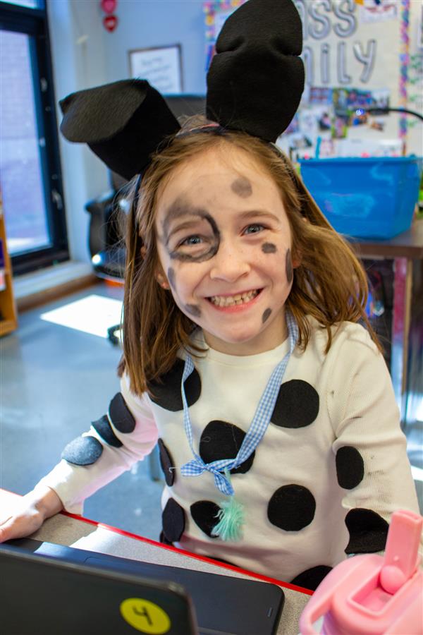 girl smiling dressed as dalmatian dog with ears